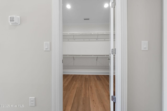 spare room with a tray ceiling, wood finished floors, a ceiling fan, and visible vents