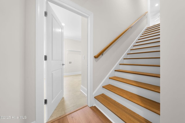 stairway featuring baseboards and wood finished floors