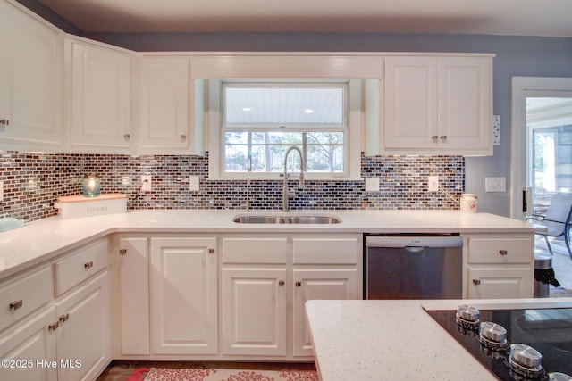 kitchen featuring tasteful backsplash, white cabinets, black electric stovetop, stainless steel dishwasher, and a sink