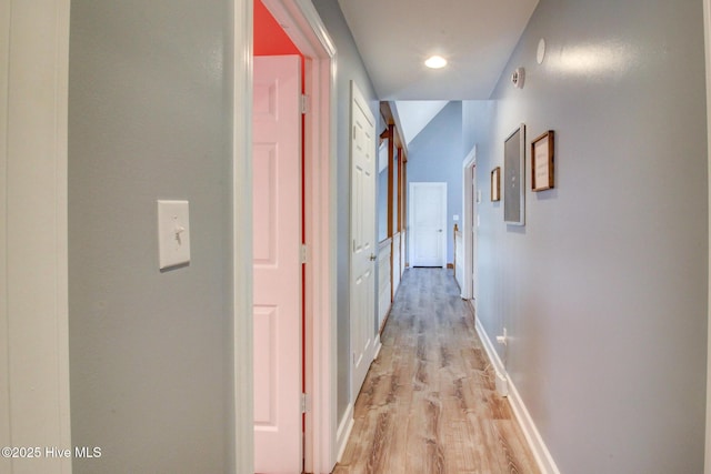 hall featuring light wood finished floors and baseboards