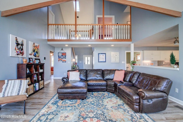 living room with high vaulted ceiling, baseboards, visible vents, and wood finished floors