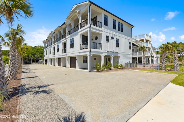 view of building exterior featuring driveway, a garage, and cooling unit