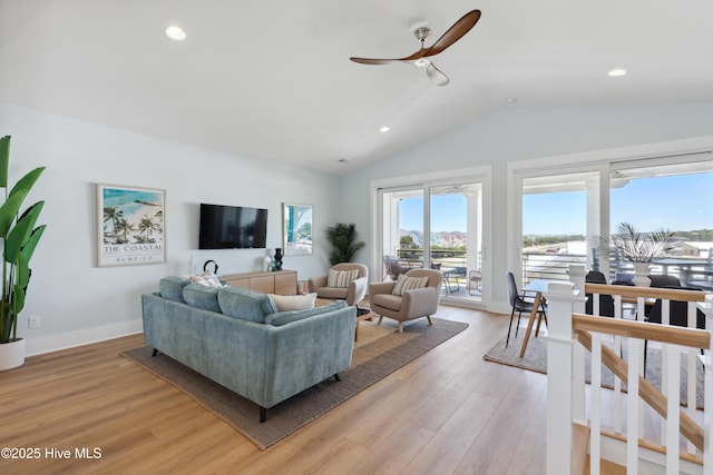 living room featuring lofted ceiling, ceiling fan, recessed lighting, baseboards, and light wood-style floors