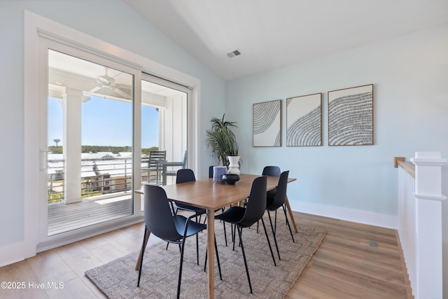dining space featuring visible vents, lofted ceiling, baseboards, light wood-type flooring, and a ceiling fan