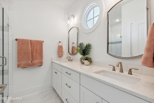 bathroom with marble finish floor, a sink, a shower stall, and baseboards