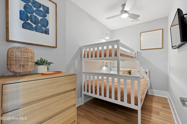 bedroom featuring baseboards, wood finished floors, and visible vents