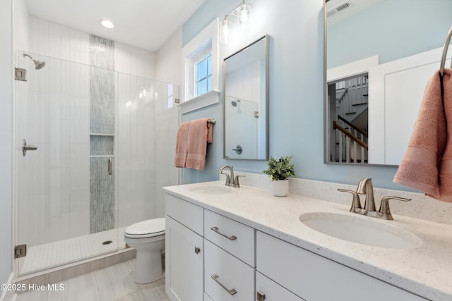 bathroom featuring visible vents, a sink, toilet, and a shower stall
