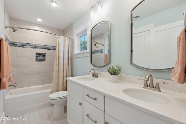 bathroom featuring double vanity, a sink, shower / tub combo with curtain, and toilet