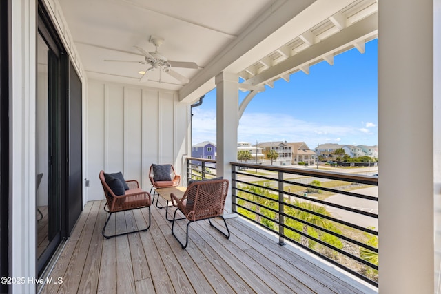 wooden terrace with a residential view and a ceiling fan