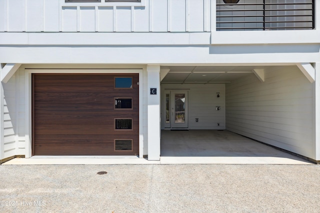 garage with a carport and concrete driveway