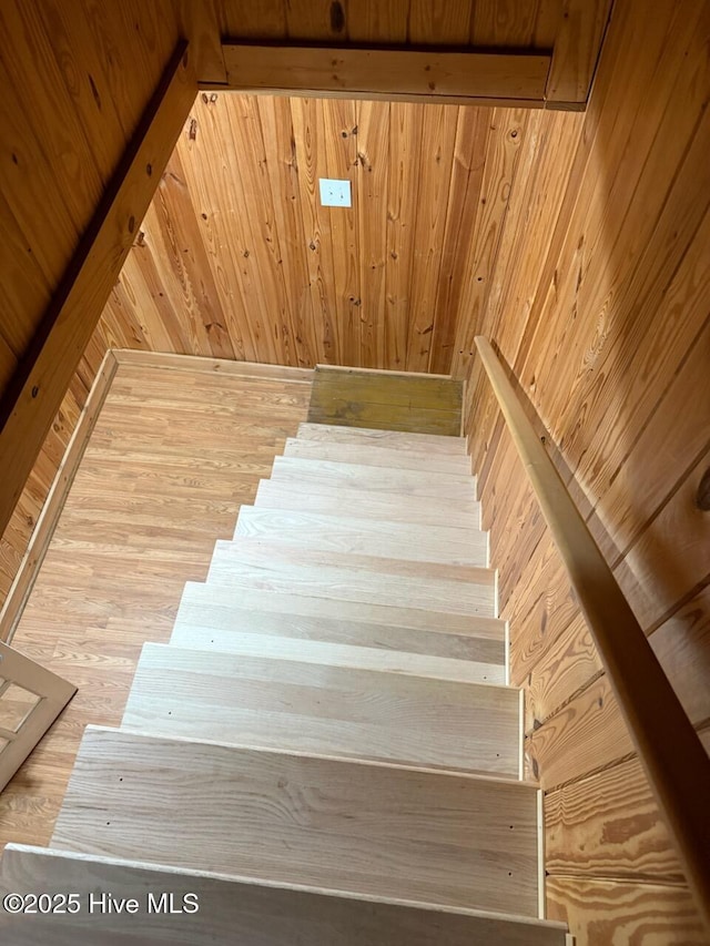 staircase featuring hardwood / wood-style flooring and wood walls