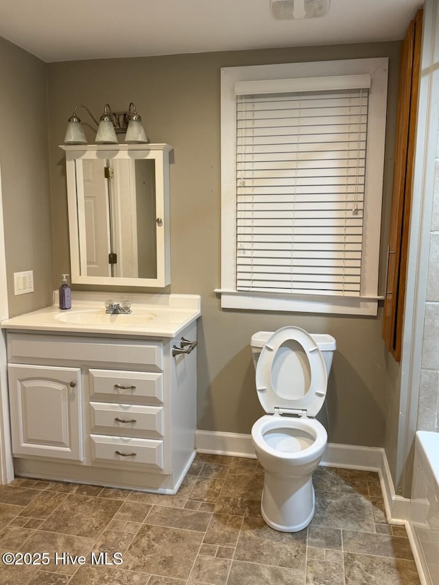 bathroom featuring vanity, a bathtub, and toilet