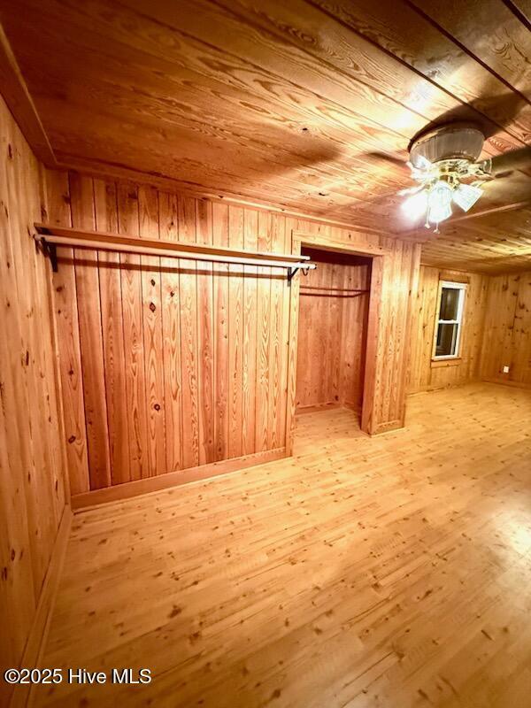 additional living space featuring wooden walls, wood ceiling, and light hardwood / wood-style floors