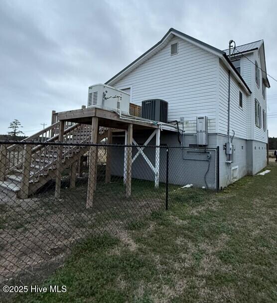 back of house featuring a yard and central AC unit