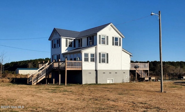 rear view of property featuring a wooden deck and a yard