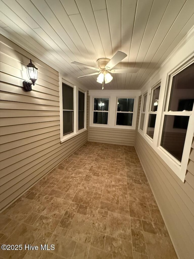 unfurnished sunroom with ceiling fan and wood ceiling