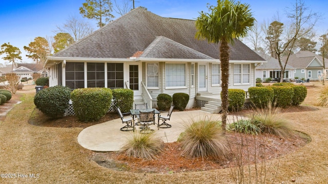 rear view of property featuring a sunroom and a patio