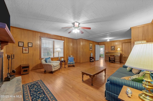 living area with a ceiling fan and wood finished floors