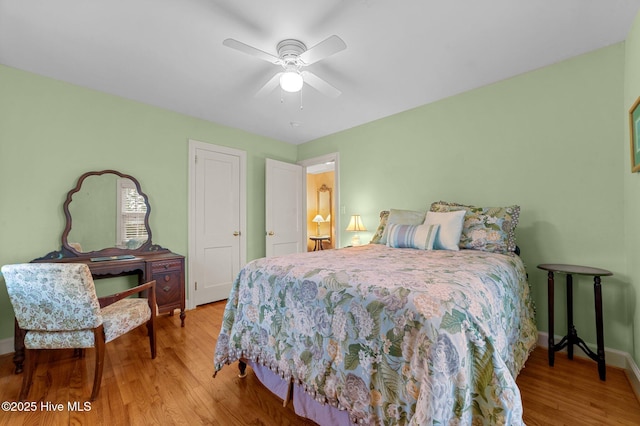 bedroom featuring ceiling fan, baseboards, and wood finished floors