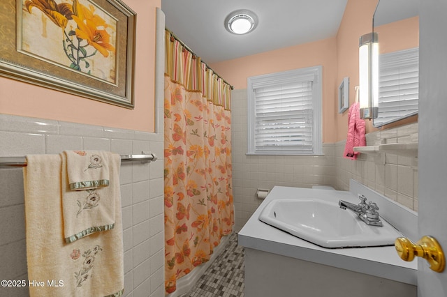 full bathroom featuring a wainscoted wall, tile walls, and a shower with shower curtain