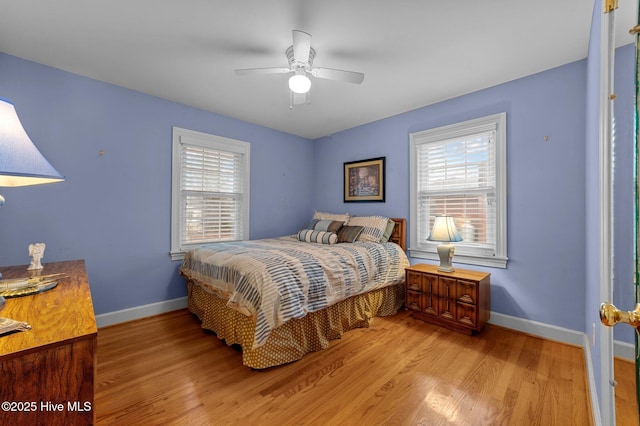 bedroom featuring light wood-type flooring, baseboards, and a ceiling fan