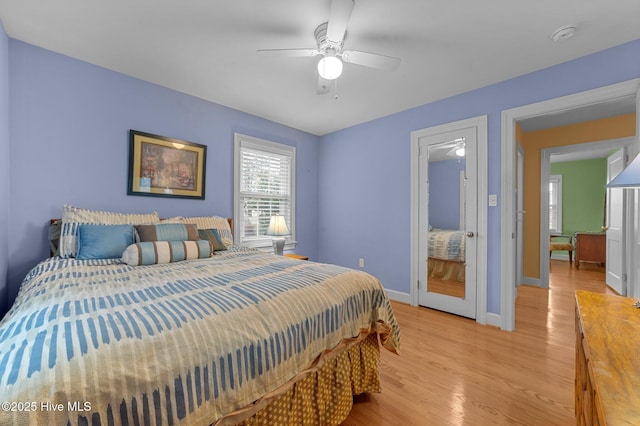 bedroom with light wood-style floors, baseboards, and a ceiling fan