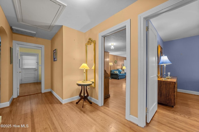 corridor with visible vents, wood finished floors, attic access, and baseboards