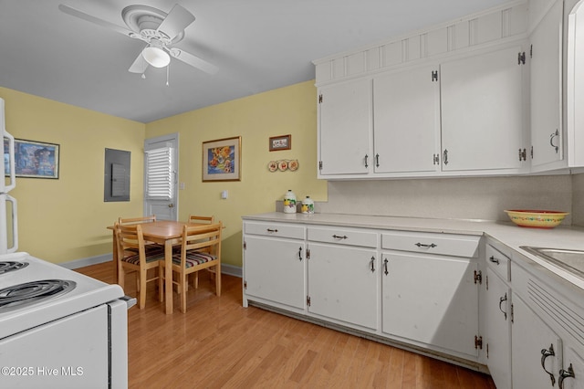 kitchen featuring light countertops, light wood finished floors, and white cabinetry