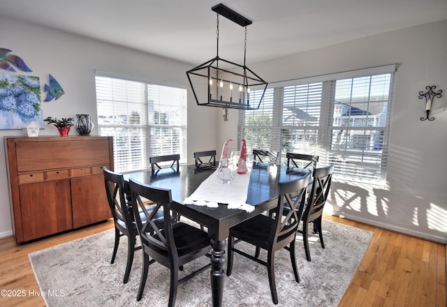 dining area with a chandelier, plenty of natural light, and light wood-style floors