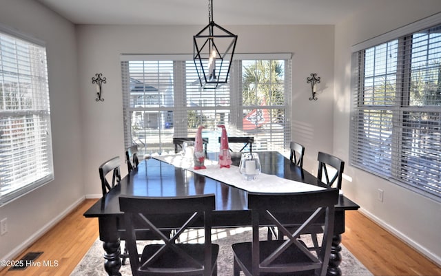 dining area featuring light wood-style floors, visible vents, and baseboards