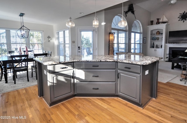 kitchen featuring open floor plan, vaulted ceiling, gray cabinets, and light wood-style floors