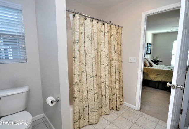 bathroom featuring baseboards, tile patterned flooring, toilet, and connected bathroom