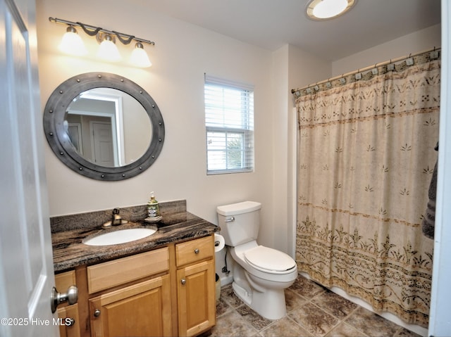 bathroom with toilet, curtained shower, tile patterned floors, and vanity