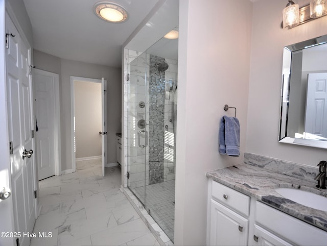 full bath featuring marble finish floor, a shower stall, vanity, and baseboards