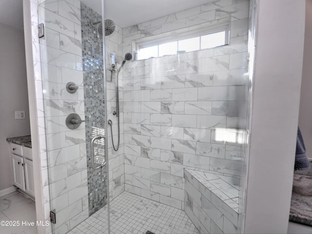 full bathroom featuring marble finish floor, a shower stall, and vanity