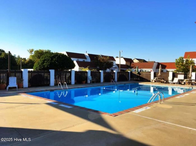 pool featuring a patio and fence