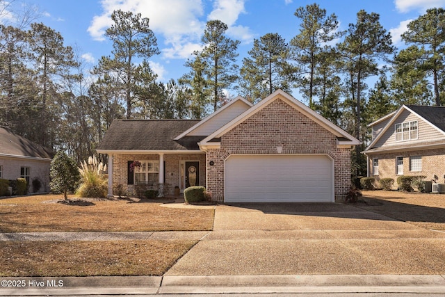 view of front facade featuring driveway, an attached garage, a shingled roof, and brick siding