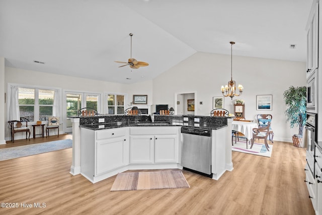 kitchen featuring appliances with stainless steel finishes, open floor plan, white cabinets, dark stone countertops, and light wood-type flooring