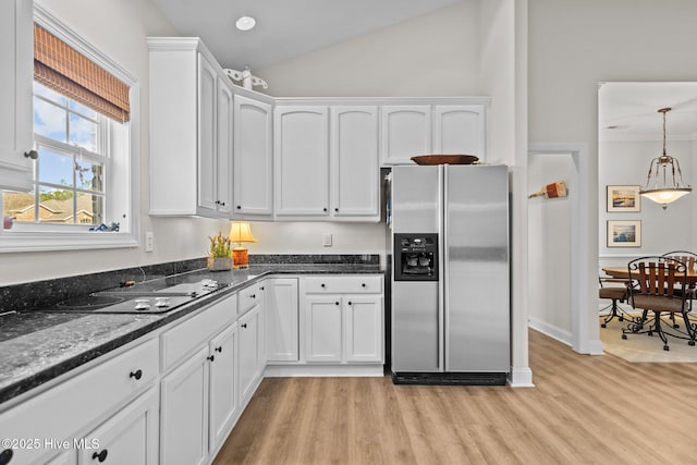 kitchen featuring dark stone countertops, hanging light fixtures, light wood-type flooring, white cabinetry, and stainless steel refrigerator with ice dispenser