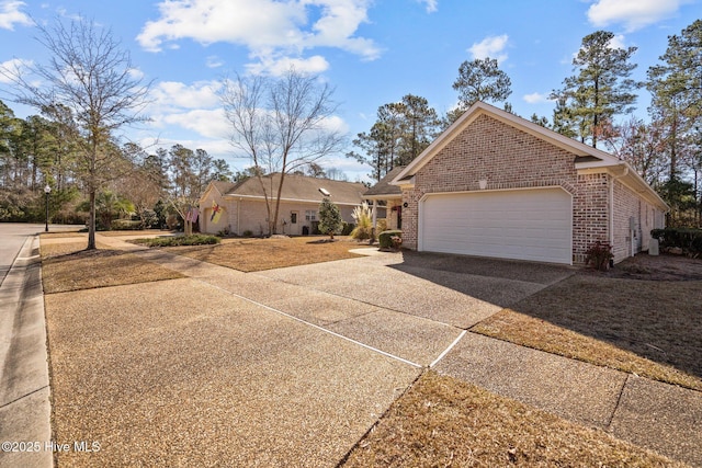 view of front of property featuring driveway, an attached garage, and brick siding