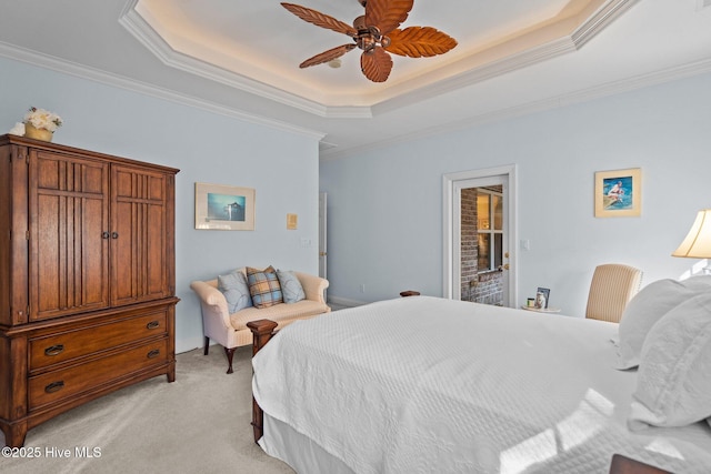 bedroom featuring ceiling fan, a tray ceiling, ornamental molding, and light colored carpet