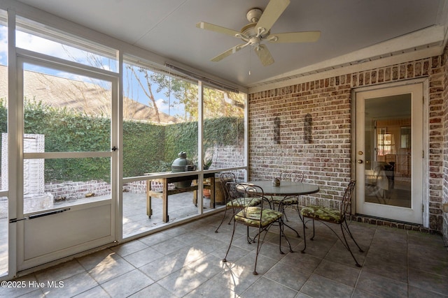 unfurnished sunroom featuring a ceiling fan