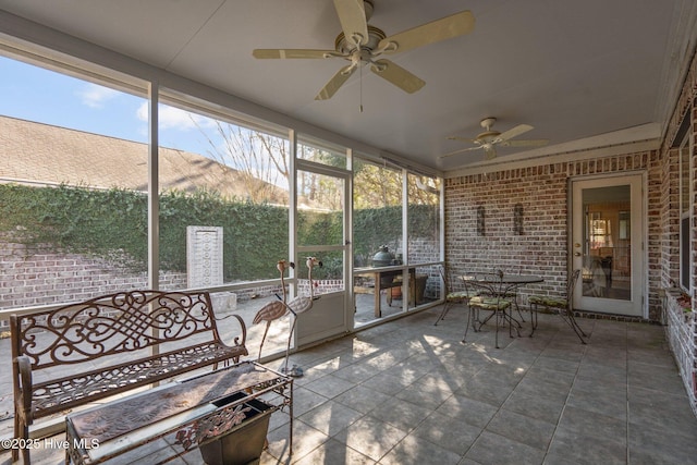 unfurnished sunroom featuring a ceiling fan