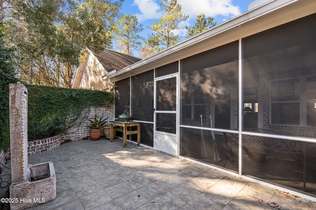 view of patio with a sunroom and fence