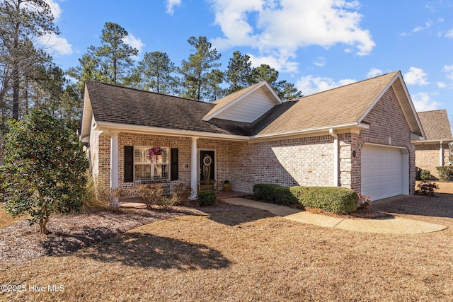 view of front of property with a garage, brick siding, a porch, and a shingled roof