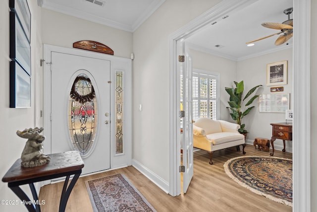 foyer entrance featuring light wood-type flooring, baseboards, and ornamental molding