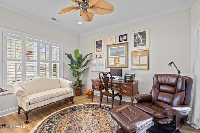 home office with baseboards, wood finished floors, visible vents, and crown molding