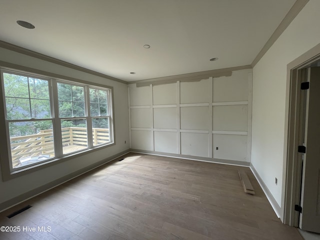 empty room featuring ornamental molding, wood finished floors, baseboards, and recessed lighting