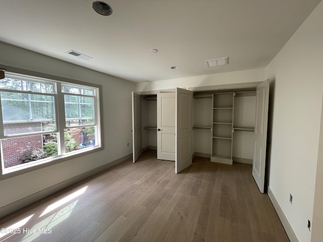 unfurnished bedroom with light wood finished floors, baseboards, and recessed lighting