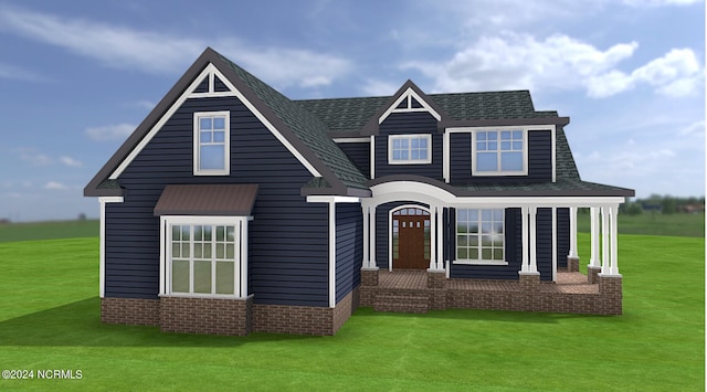 view of front facade with a front yard and a shingled roof